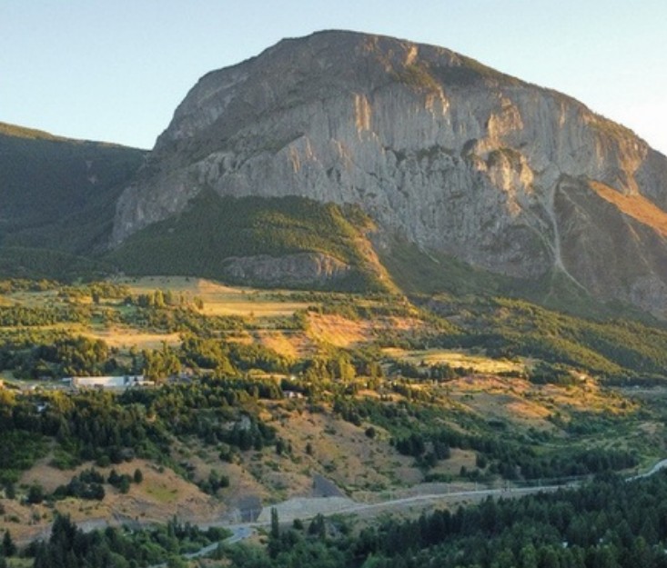 Vista del valle de Coyhaique al atardecer, con el cerro y el bosque que rodean el parque.